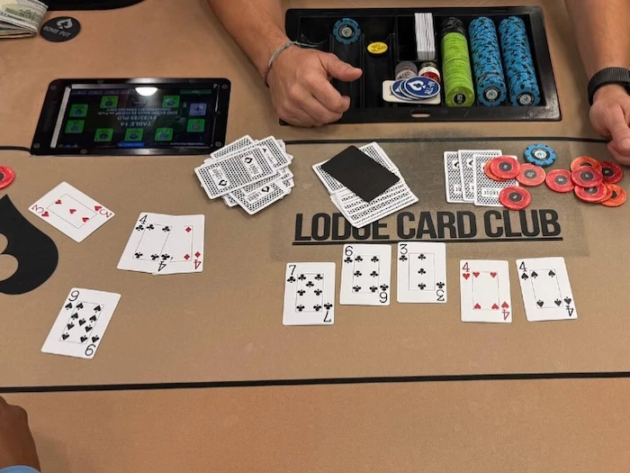 Lodge Card Club Poker Table Chips and Cards Lodge Card Club branded poker table with chips and cards during an active gameCaption: A Lodge Card Club poker table mid-session. Players were told to take their chips home when agents arrived on March 10.