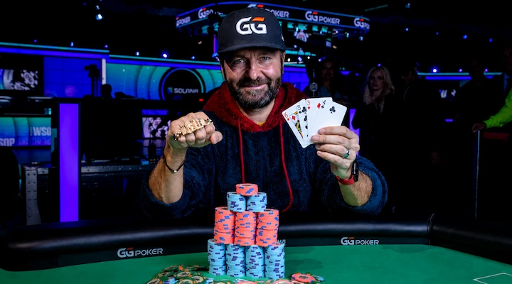 Daniel Negreanu holding a WSOP bracelet and winning cards at the GGPoker WSOP, the all-time WSOP earnings leader with 8 bracelets