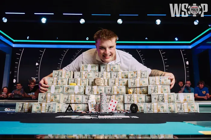 Lucas Jumalon leaning over the stacked cash and gold bracelet after winning the WSOP 2026 Main Event for $10,000,000