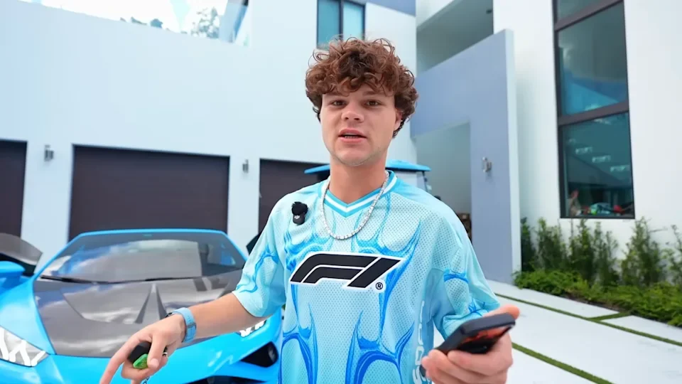 YouTuber Jack Doherty standing outside a house holding his phone in a still from one of his videos